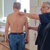 тренер проводит коррекцию осанки с помощью массажных техник"