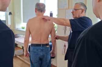 тренер проводит коррекцию осанки с помощью массажных техник"